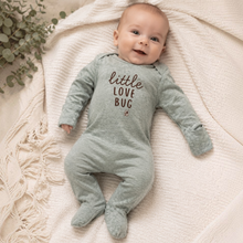 Load image into Gallery viewer, A baby wearing a sage green footed sleeper with 'little LOVE BUG' printed in brown on the front.