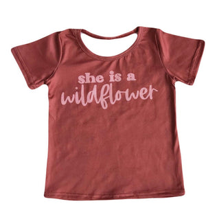 Rust colored girls t-shirt with pink writing "She is a wildflower"