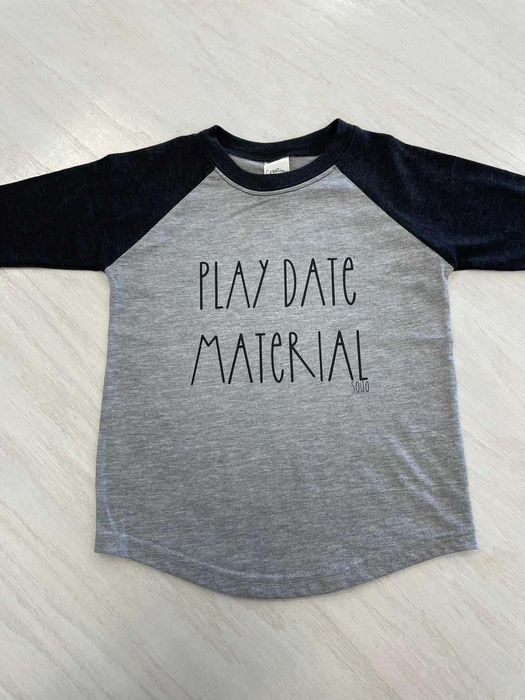 Gray and black baseball style shirt with wording 