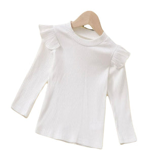 White ribbed long sleeve shirt with shoulder ruffles.
