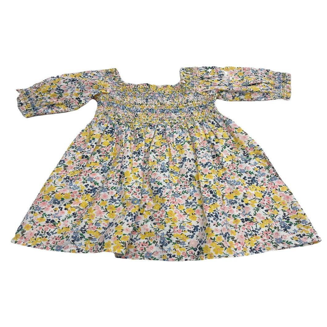 Toddler dress with spring-colored flowers, square neck- line and sleeves.